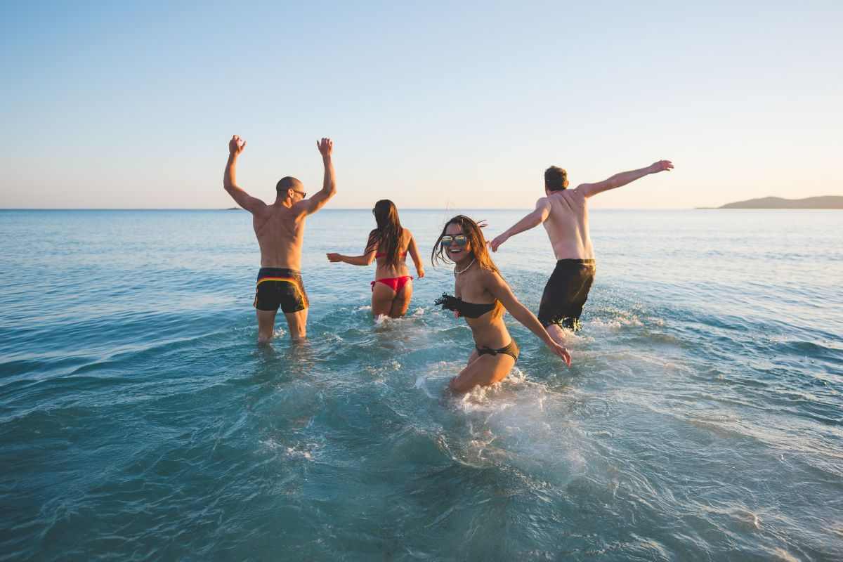 Amici fanno il bagno al mare insieme