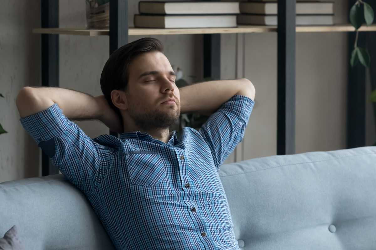 Uomo si rilassa seduto sul divano