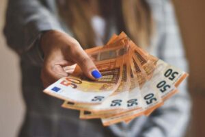 donna che porge delle banconote da 50 euro