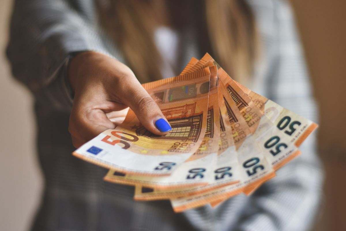 donna che porge delle banconote da 50 euro