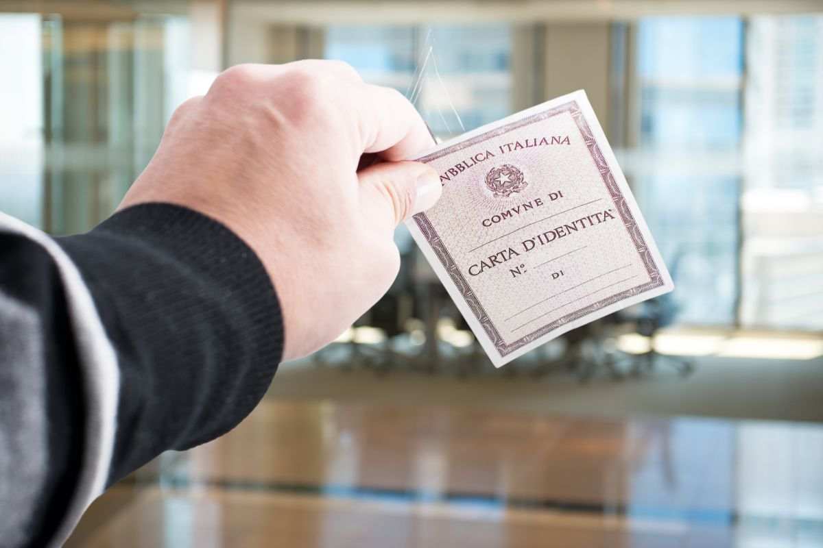 persona con in mano carta identità cartacea italiana
