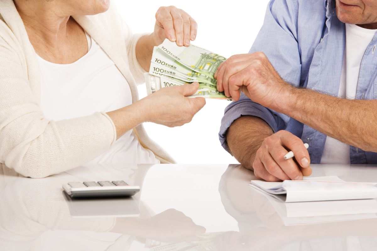 persone anziane che hanno in mano delle banconote da 100 euro