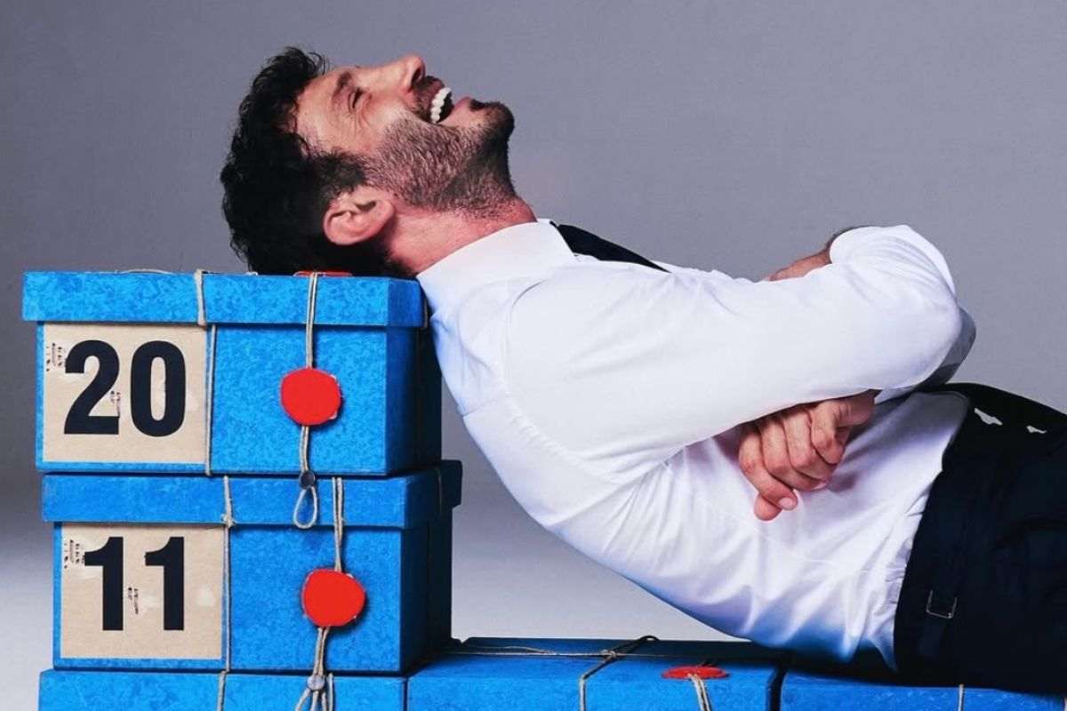 De Martino sdraiato sui pacchi di Affari Tuoi