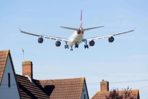 aereo che atterra vicino alle case