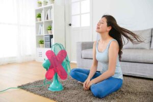 ragazza col ventilatore e una x sopra al ventilatore