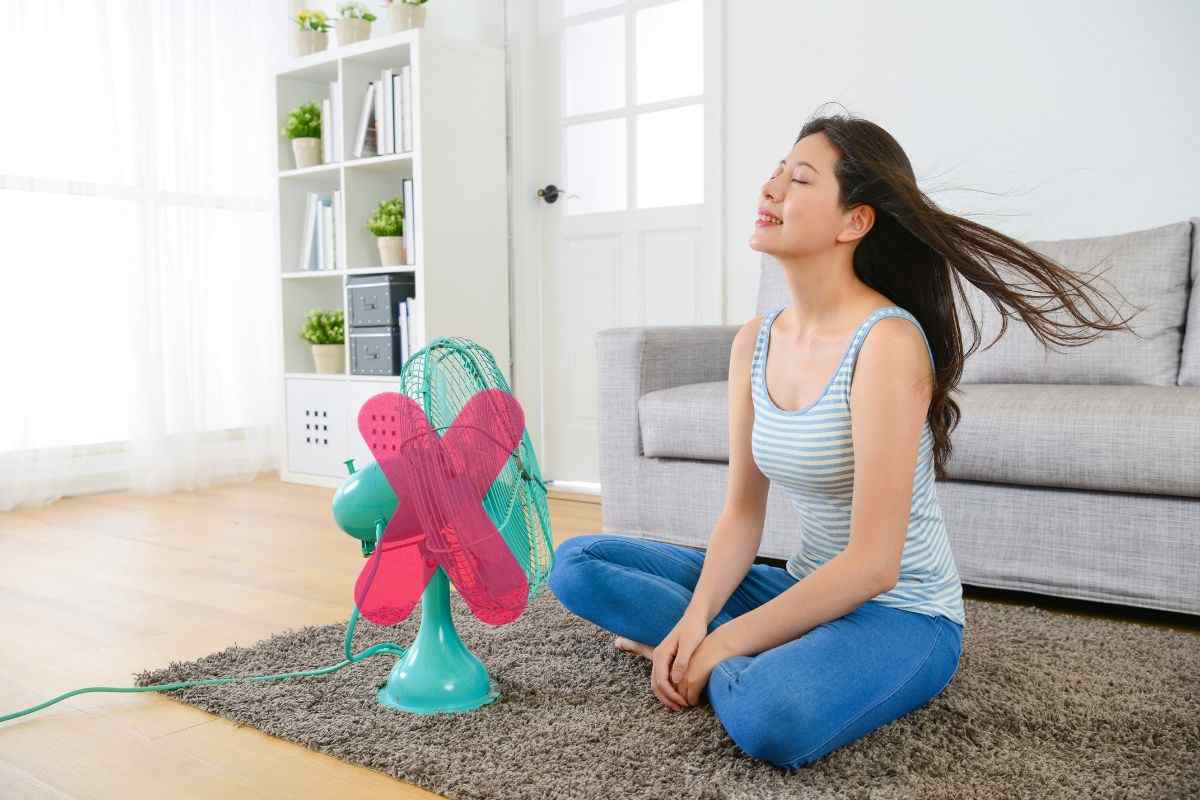 ragazza col ventilatore e una x sopra al ventilatore